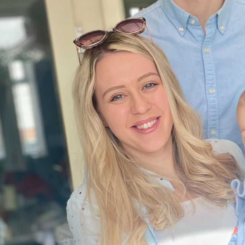 Hayley Bailey, baby and toddler sleep and parenting coach, smiling in a neutral setting.